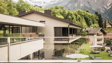 Un edificio moderno con un balcón que da a un paisaje montañoso.