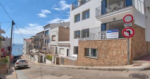 A residential street with a stone facade building, a 'TO RENT A LOUER' sign, and a 'No Right Turn' sign. - Ground-floor apartment with a spacious terrace in the center of Calella de Palafrugell (Calella de Palafrugell)