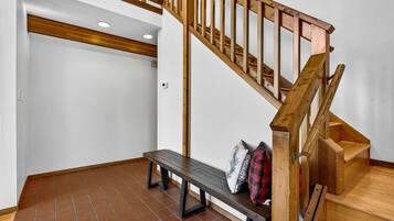 Una escalera con barandillas de madera y un banco con almohadones.