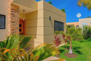 A modern building with a stone facade, large windows, and a satellite dish. - 2 Bed, Encuentro Retreat, Casa Tranquila (sosua)