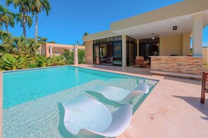 A modern pool area with clear water, lounge chairs, and a patio with outdoor seating. - 2 Bed, Encuentro Retreat, Casa Tranquila (sosua)