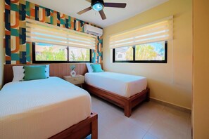A hotel room with two beds, a ceiling fan, air conditioning, and large windows with blinds. - 2 Bed, Encuentro Retreat, Casa Tranquila (sosua)