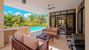 Ein Balkon mit Pool, Gartenmöbeln und Grill.
