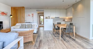 A modern apartment with a living area, dining space, and kitchenette. - Modern three-bedroom apartment with pool in the center (Calella de Palafrugell)