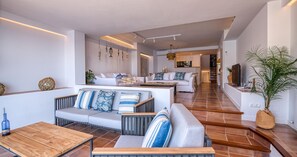 Ein modernes Wohnzimmer mit einer Sofagarnitur, einem Couchtisch und einem Fernseher.