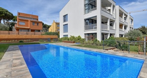 Ein rechteckiger Pool mit klarem, blauem Wasser, umgeben von einer Holzterrasse.