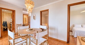 A dining area with a round table, chairs, and a chandelier. - Apartment with Beautiful Sea Views and Pool in Calella · Perfect to Relax (Calella de Palafrugell)