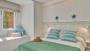Une chambre avec un lit, une fenêtre donnant sur un beau paysage et un mur décoré de deux étoiles.