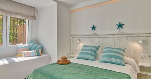 A bedroom with a bed, a window with a view, and a wall with two star decorations. - Spacious family apartment 100m from the sea with terrace, parking and air conditioning (Llafranc)