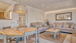 Un salon moderne avec une table de salle à manger ronde en bois, un canapé et une table basse.