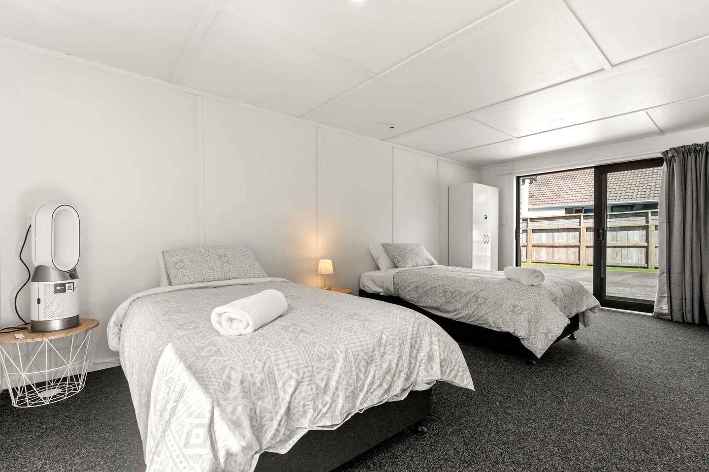 Ett hotellrum med två sängar, ett skrivbord med en lampa, en hårtork och utsikt över omgivningarna.