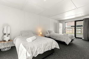 Ett hotellrum med två sängar, ett skrivbord med en lampa, en hårtork och utsikt över omgivningarna.
