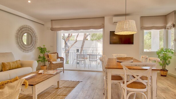 A modern living room with a sofa, coffee table, dining table, chairs, and a balcony with a view. - Elegant apartment 100m from the beach with parking and air conditioning (Llafranc)