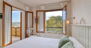 Una camera da letto con un letto grande, vista sull'esterno e un balcone.