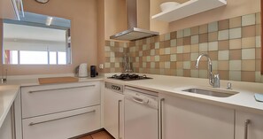 A modern kitchen with a gas stove, dishwasher, and a sink. - Charming beachfront apartment with sea views just 10 meters from the beach in Cala de Calau, Calella de Palafrugell. (Calella de Palafrugell)