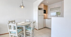 Eine kompakte Küche mit eingebautem Backofen und einem Fenster über der Spüle.