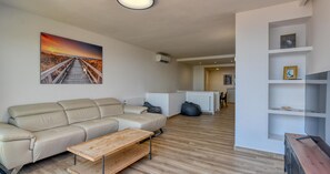 Ein Wohnzimmer mit einer Couch, einem Couchtisch und einem Gemälde an der Wand.
