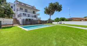 A residential property with a swimming pool, a two-story building, and a well-maintained lawn. - Spectacular and spacious penthouse with communal pool in the Golfet area (Calella de Palafrugell)