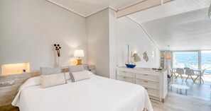 A bedroom with a large bed, bedside lamps, a dresser, and a view of the sea through a balcony. - Charming beachfront apartment with sea views just 10 meters from the beach in Cala del Calau, Calella de Palafrugell (Calella de Palafrugell)
