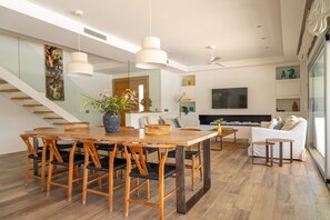A modern interior with a dining area, a sofa, and a TV.