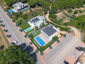 Ein modernes Wohnhaus mit Schwimmbad, Solaranlage und einem gepflegten Garten.