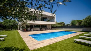 A modern two-story house with a swimming pool, outdoor seating, and a well-maintained lawn. - Modern chalet with private pool (Calella de Palafrugell)