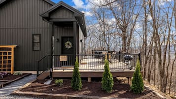 A dark-colored building with a porch, a welcome sign, and a sign indicating a lodge.