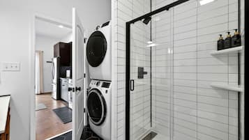 A modern bathroom with a shower, a toilet, and a sink.