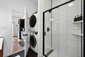 A modern bathroom with a shower, a toilet, and a sink.
