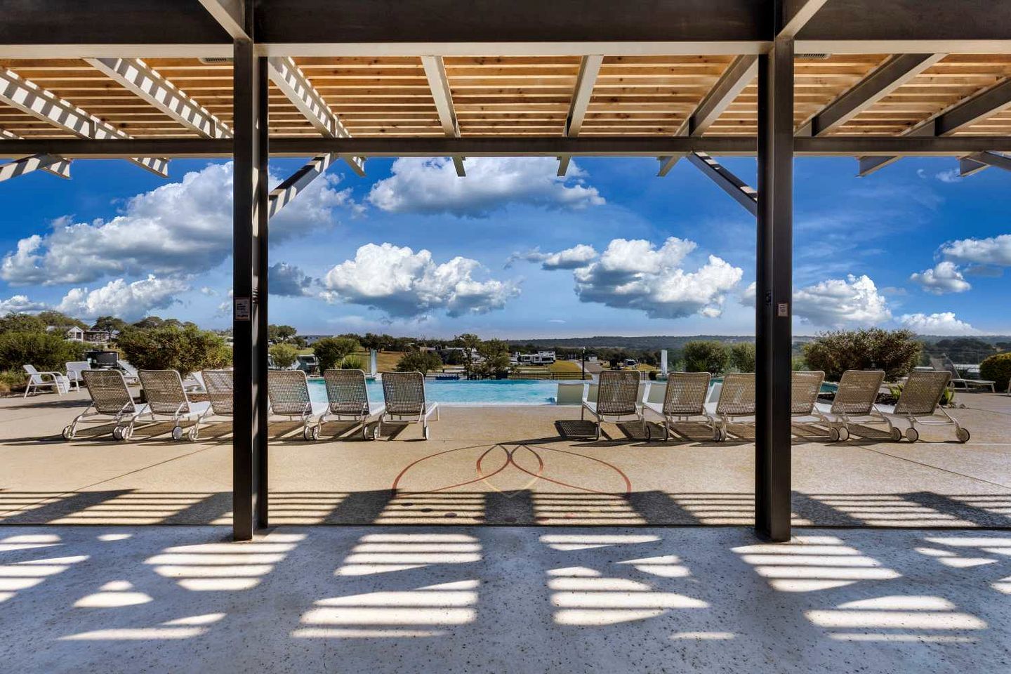 Un espace extérieur abrité, doté de chaises longues et d’une piscine.
