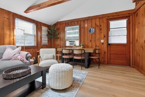 Ein gemütliches Wohnzimmer mit Sofa, Sesseln, einem Couchtisch und einem Essbereich mit Tisch und Stühlen.