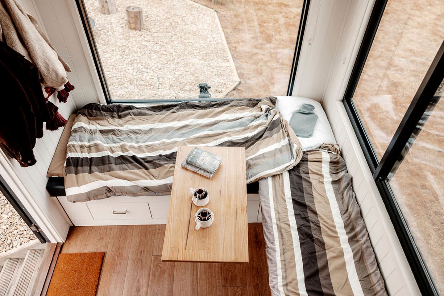 A cozy room with a bed, a small table, and a window.