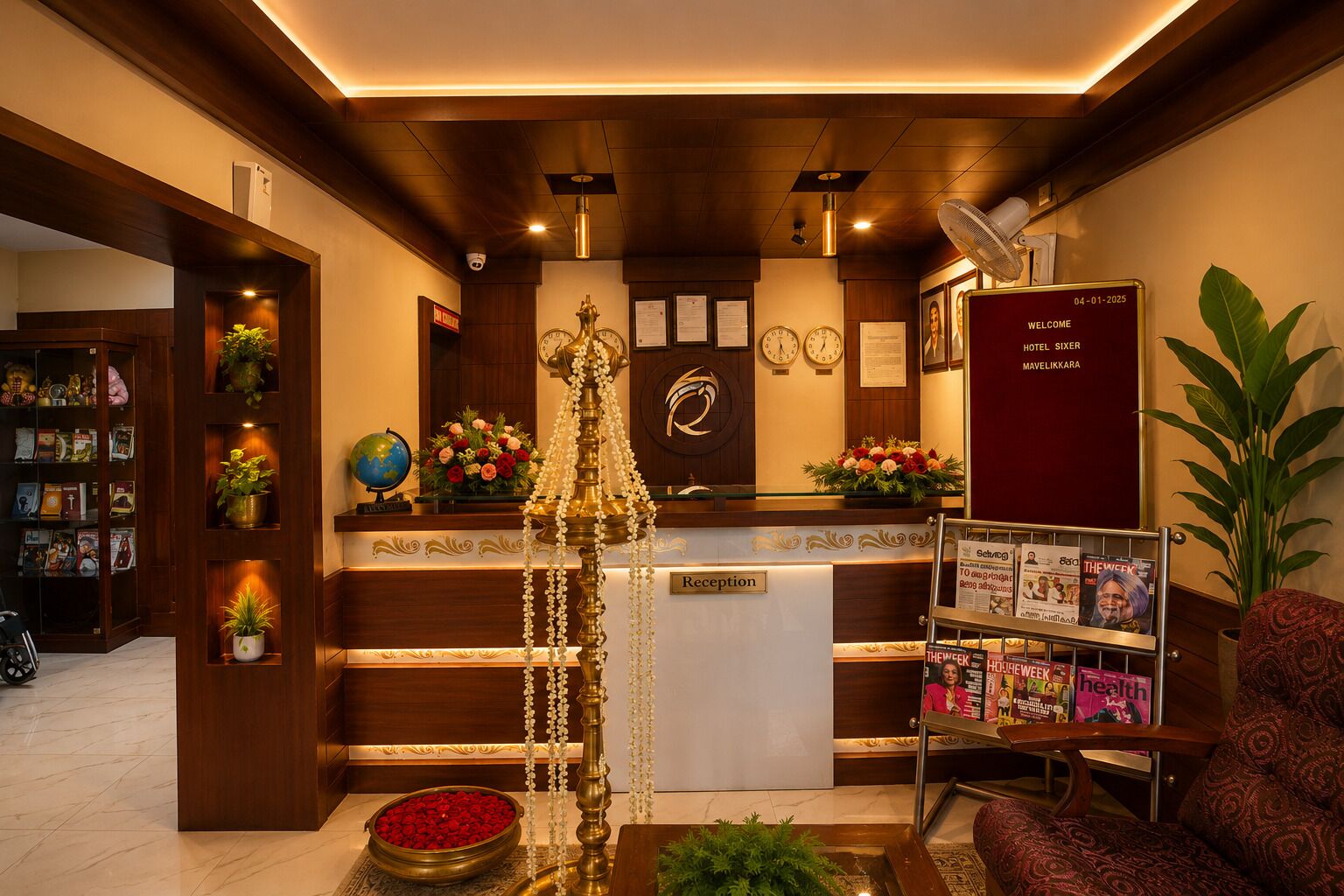 A hotel reception area with a reception desk, a clock, a globe, and a welcome sign.