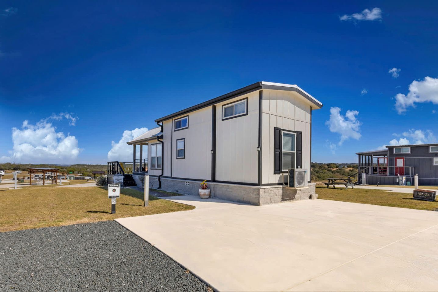 A modern building with a flat roof, a covered entrance, and a small porch.