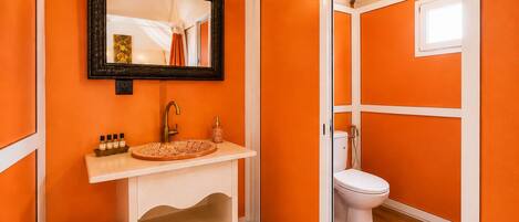 A bathroom with a white sink, a mirror, and a toilet.