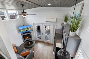 Ein modernes Wohnzimmer mit Kamin, Fernseher und Essbereich mit Blick.