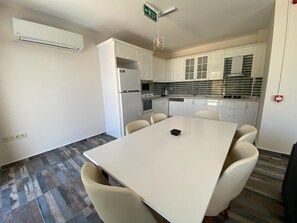 A modern kitchen with white cabinets, a dining table with chairs, and a built-in oven. - Villa with private pool in Bodrum. 10 mn to Yalıkavak Marina, 5 mn to Gümüşlük. (Bodrum)