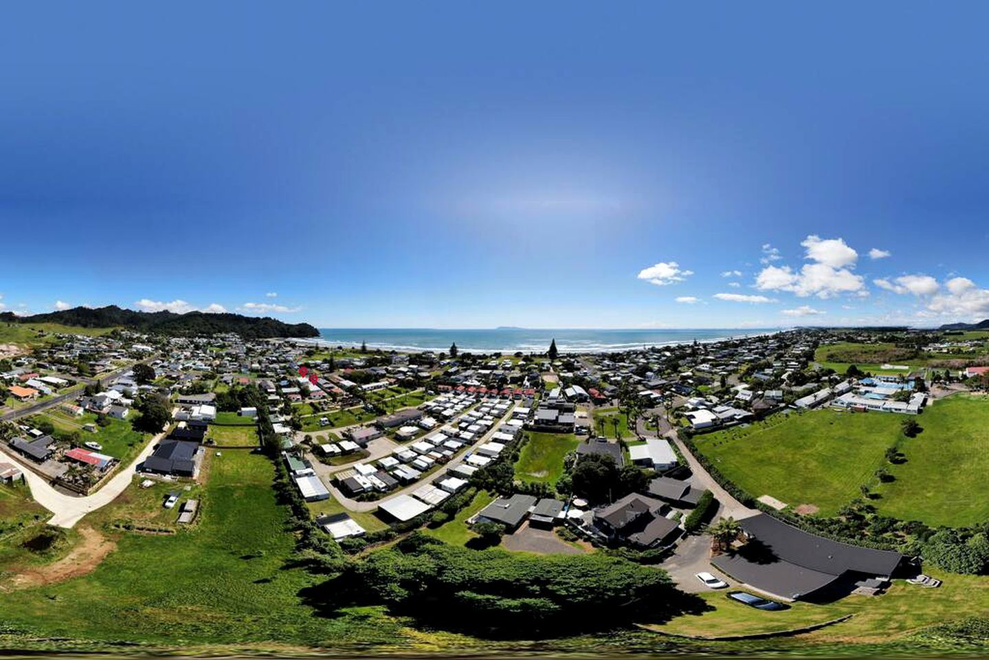 A coastal town with a marina, green spaces, and a mix of residential and commercial buildings.