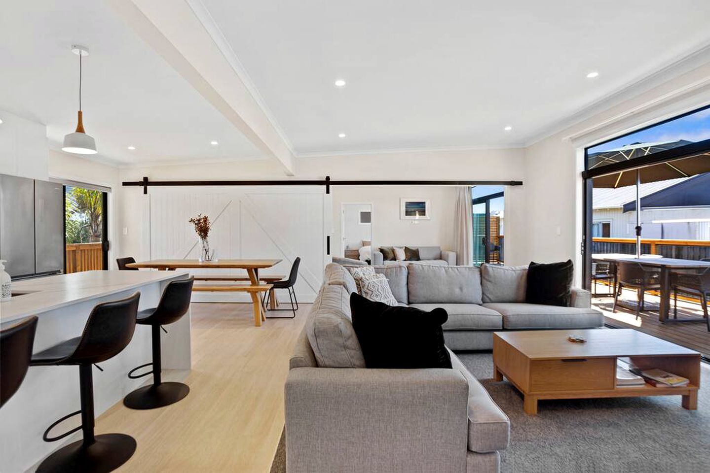 Ein modernes Wohnzimmer mit Sofa, Couchtisch und Essbereich.