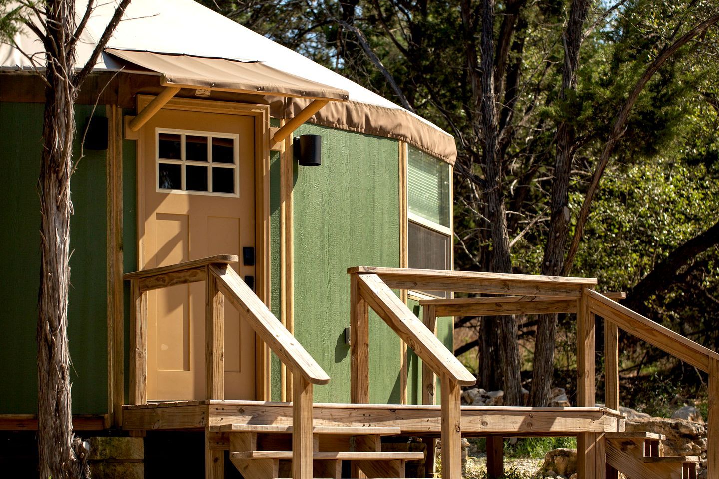 A wooden cabin with a porch and a covered entrance.