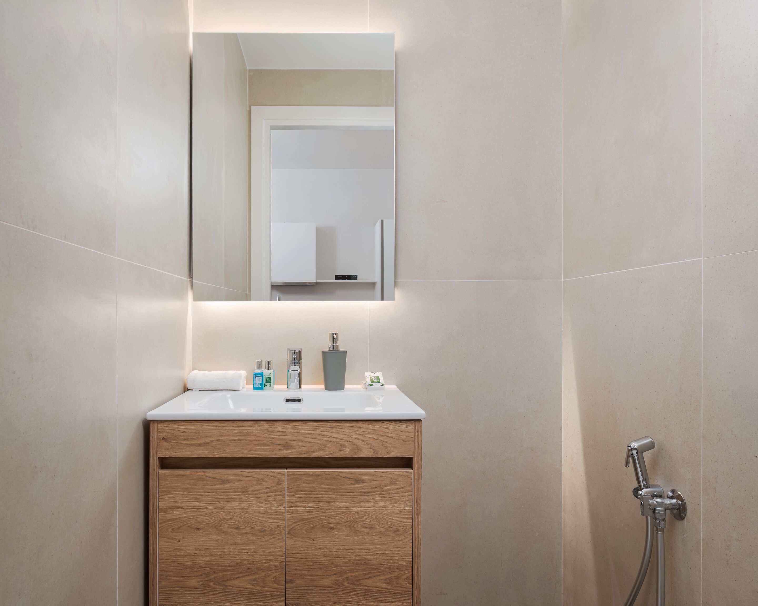 A bathroom with a wooden vanity, a mirror, a sink, and a shower.