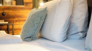 Un lit avec des oreillers et une tête de lit en bois.