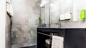 Une salle de bain moderne avec une douche à parois de verre, un meuble-lavabo noir et un porte-serviettes.