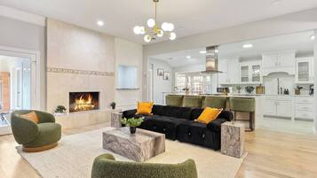 A spacious living area with a fireplace, a modern kitchen, and a dining area.