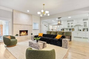 Un salón amplio con chimenea, una cocina moderna y un comedor.