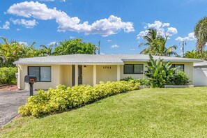 A single-story house with a flat roof, a mailbox, and a well-maintained lawn. - Stylish Surf-Themed Beach House with Private Pool Near Pompano Beach Pier, Pompano Beach Florida (Pompano Beach)