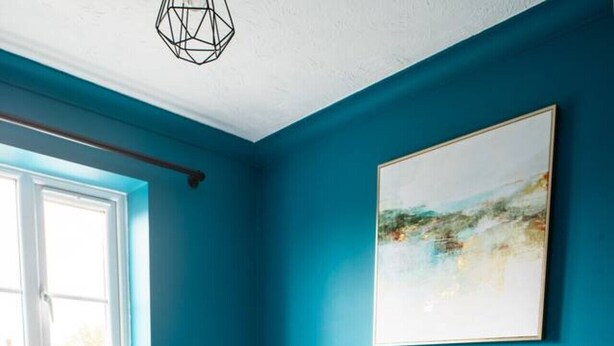 Ein Schlafzimmer mit einem Bett, einem Fenster, einer Heizung und einem Bild an der Wand.