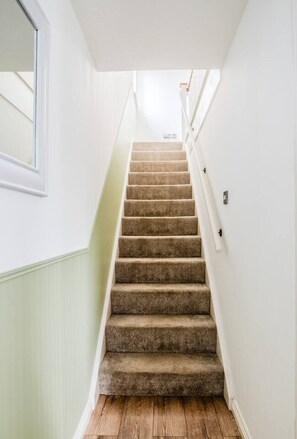 A staircase with carpeted steps leading to a landing. - The Artisan House | Stylish Bedfordshire Escape (Stewartby)