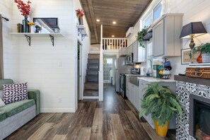 A modern kitchen with white cabinetry, a central island, and a built-in stove. - Enchanting Hill Country Vacation Home with Storybook Loft Near Fredericksburg, TX (Fredericksburg)
