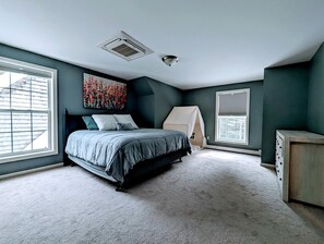Quarto com cama, janela, estrutura semelhante a uma tenda e cômoda.